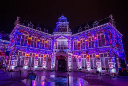 Magnificent European palace beautifully illuminated at night with warm golden lighting and architectural details